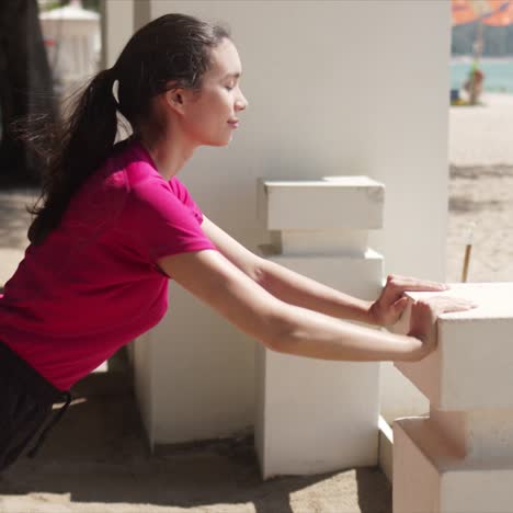 mujer deportiva haciendo push up en la playa