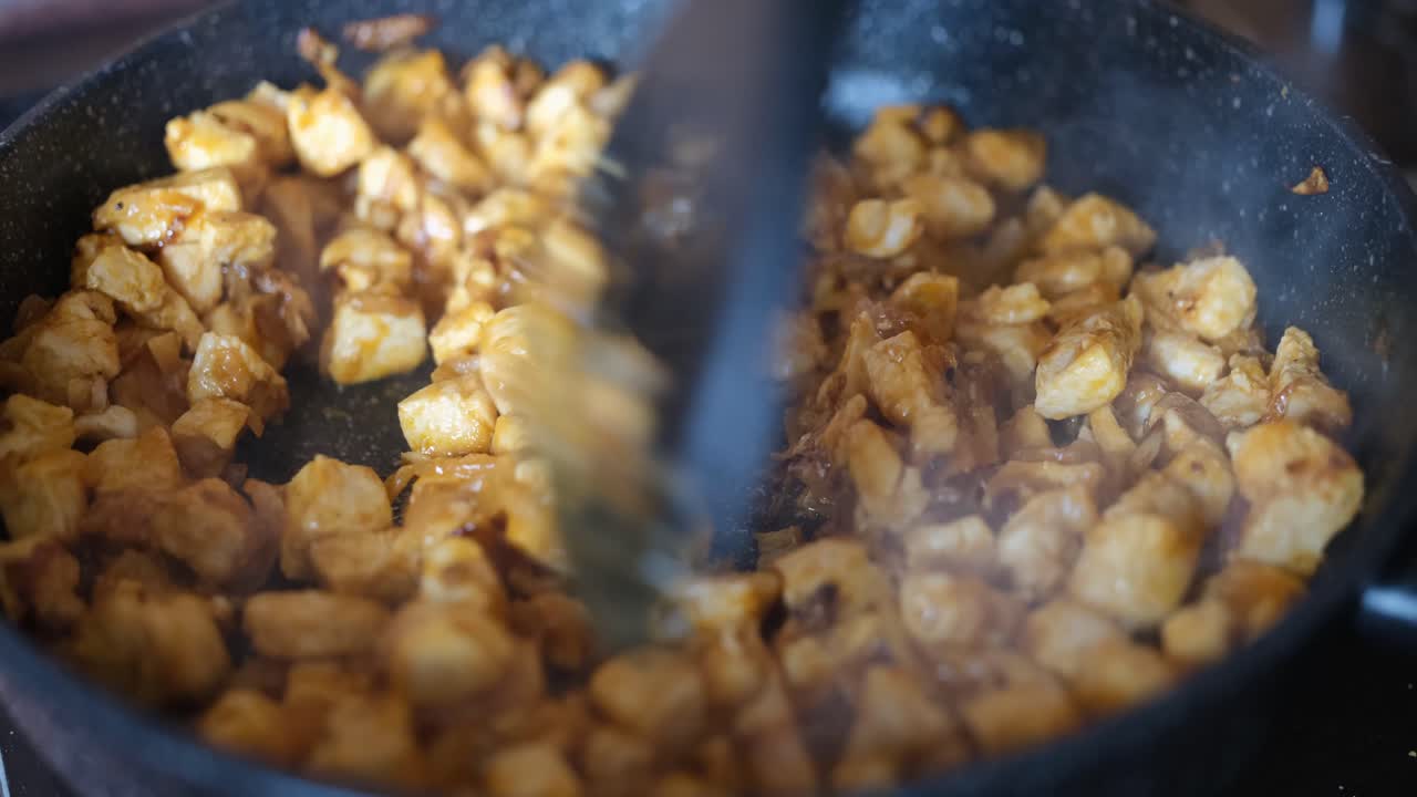 Carne e cipolle vengono fritte in padella, primo piano