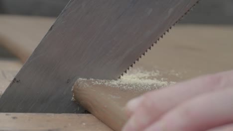 mano de obra usando una sierra manual para aserrar un trozo de madera
