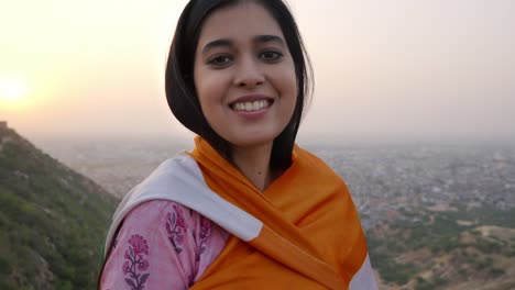 a proud and happy woman in traditional dress is wrapping an indian national flag around her