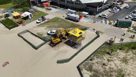 aerial view of construction site on gold coast beach with machinery and life-saving tower under clear skies