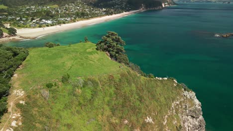 Couple-sitting-on-clifftop-edge-of-mountain