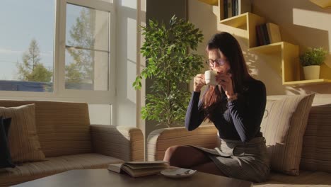 woman relaxing in a cafe reading and drinking coffee