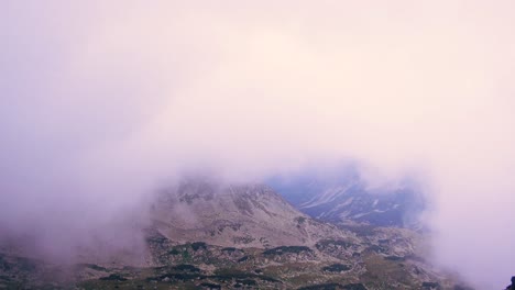 Wide-shot-of-aerial-drone-view-of-Retezat-Mountains,-Romania-seen-through-fog