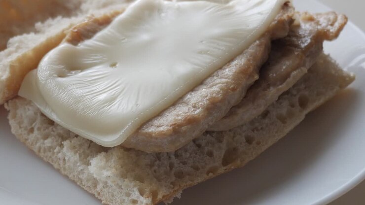 Delicious bocadillo with pork tenderloin and melted cheese on bread
