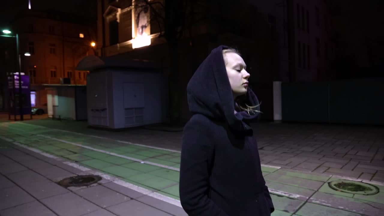 Girl taking a walk in the city in night time slow motion