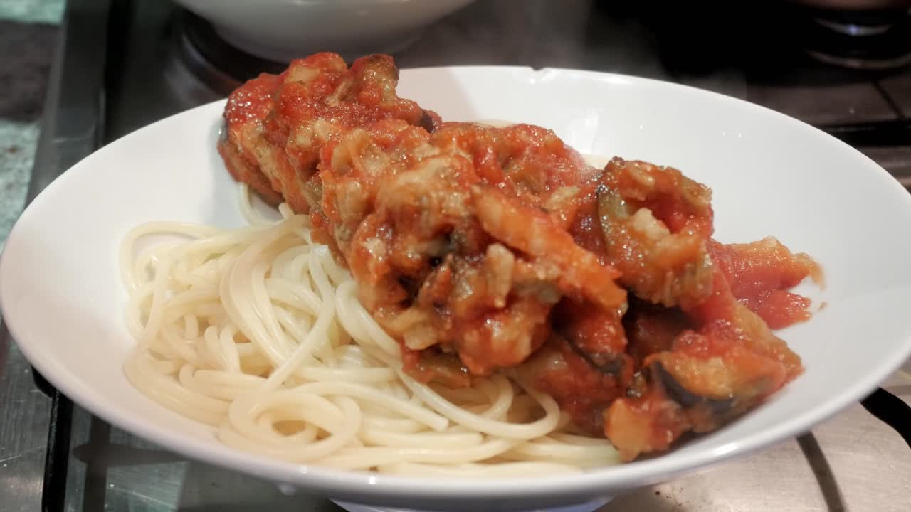 Pasta con ricco sugo di melanzane, servita calda per un pasto confortante.