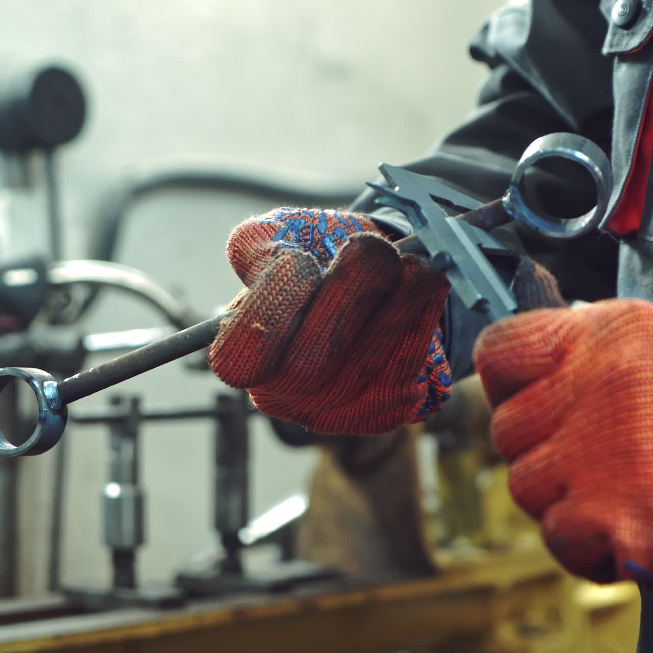 Service worker measures the ball bearing using calipers on the background of equipment at work. Close-up.