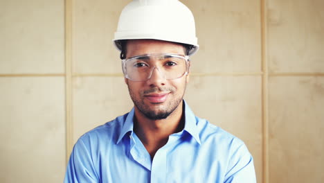 happy hispanic foreman with arms folded at building site inspection