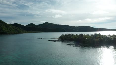 the wonderful island of fiji composed of blue calm ocean and green lush mountain - wide shot