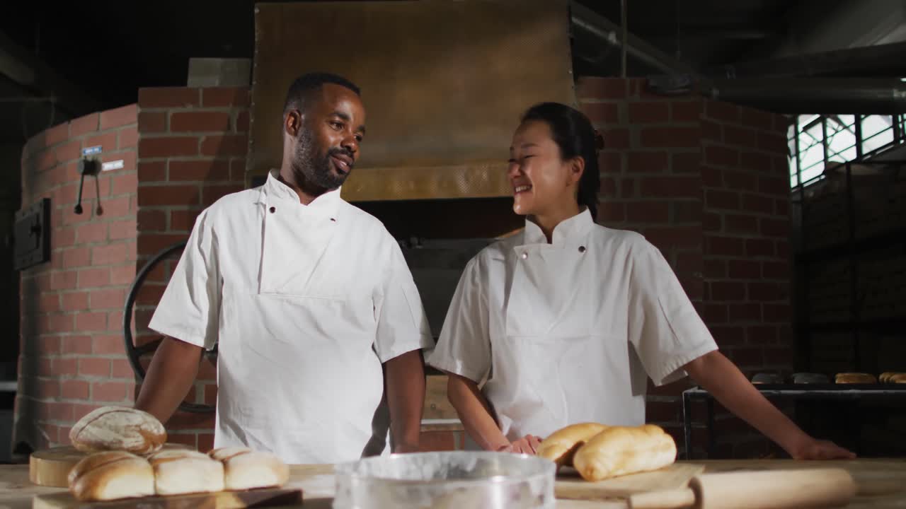Animation of two diverse male and female bakers smiling at camera in bakery