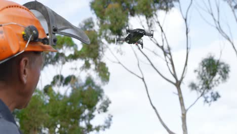 leñador operando un avión no tripulado en el bosque 4k