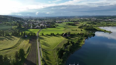 Greifensee-En-Suiza-Con-Exuberantes-Campos-Verdes-Y-Un-Lago-Sereno,-Vista-Aérea