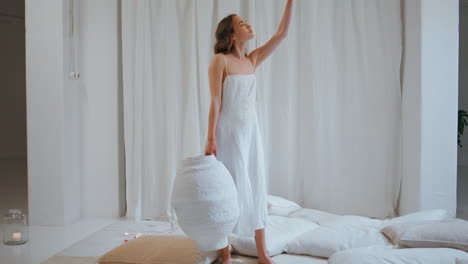 creative girl hold vase in minimalistic interior. beautiful white handmade pot