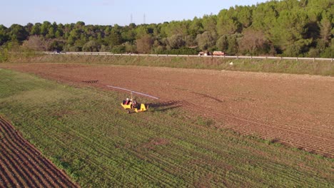 Gyroplane-rotorcraft-taxiing-on-grass-runway-in-rural-Italy,-aerial