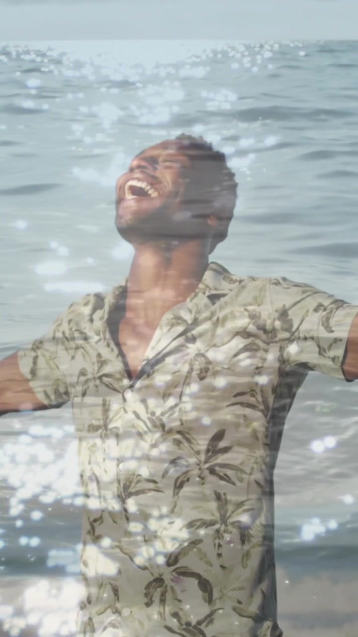 Animación de mar sobre hombre afroamericano con los brazos extendidos