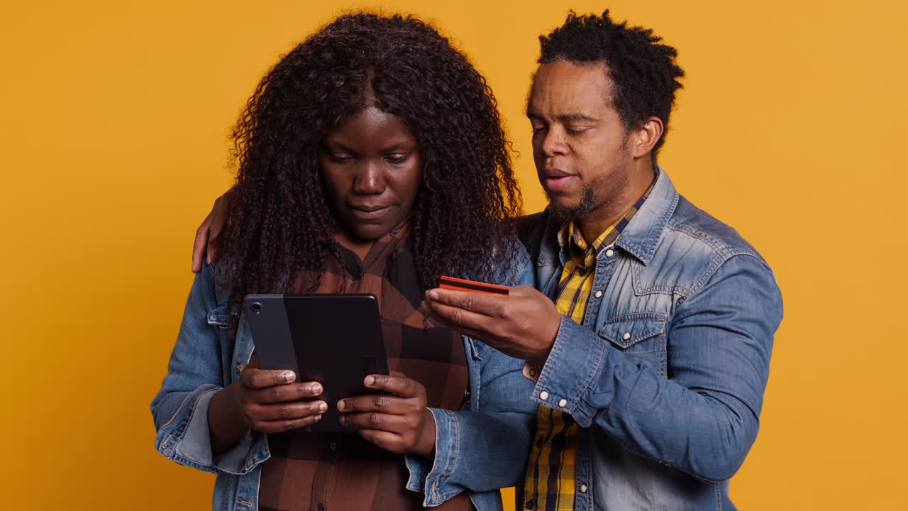 African american couple doing online shopping with their card