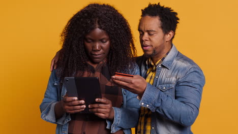 african american couple doing online shopping with their card