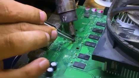 el técnico coloca el transistor pequeño en su lugar con el calentador