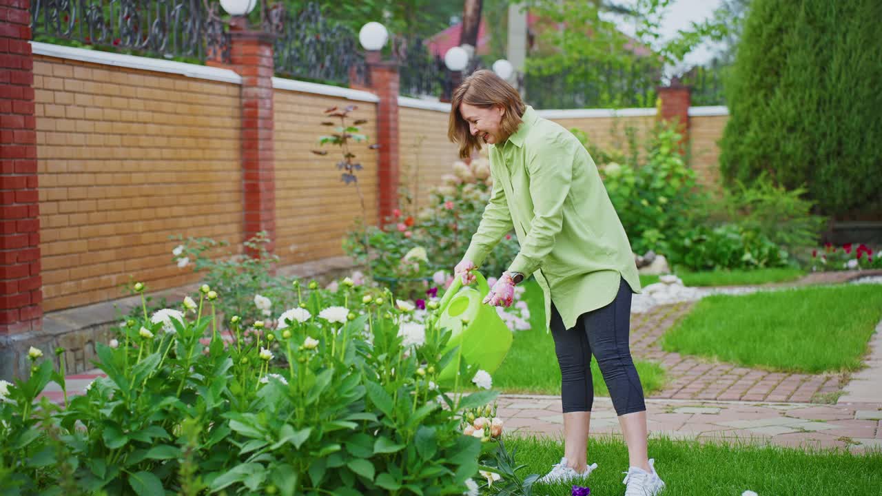 Mulher feliz regando flores em seu jardim