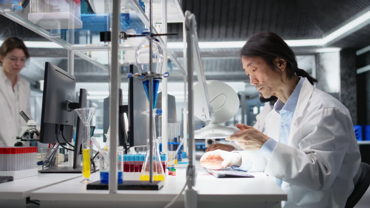 Vertical video Scientist uses laboratory lamp to examine test subject in petri dish