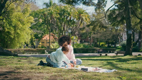 family picnic in beautiful park. mother having fun with girl.