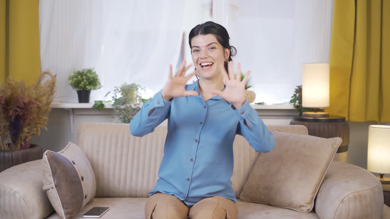 젊은 여성이 카메라를 위해 심장 기호를 만들고 있습니다.