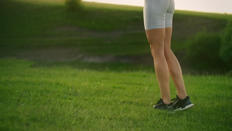 카메라는 해가 지는 동안 으로 뛰어다니는 여성 운동 선수를 따라갑니다. 각 다리에 차례로 앉아서 움직입니다.