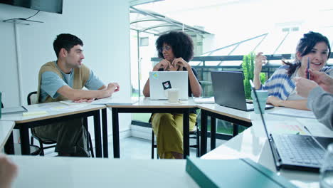 gen z businessman discussing ideas with black female coworker on meeting