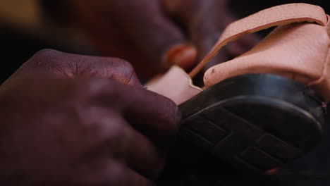 shoemaker repairing leather sandals on the street