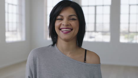 portrait of independent young mixed race woman laughing happy enjoying positive lifestyle move in new apartment looking at camera