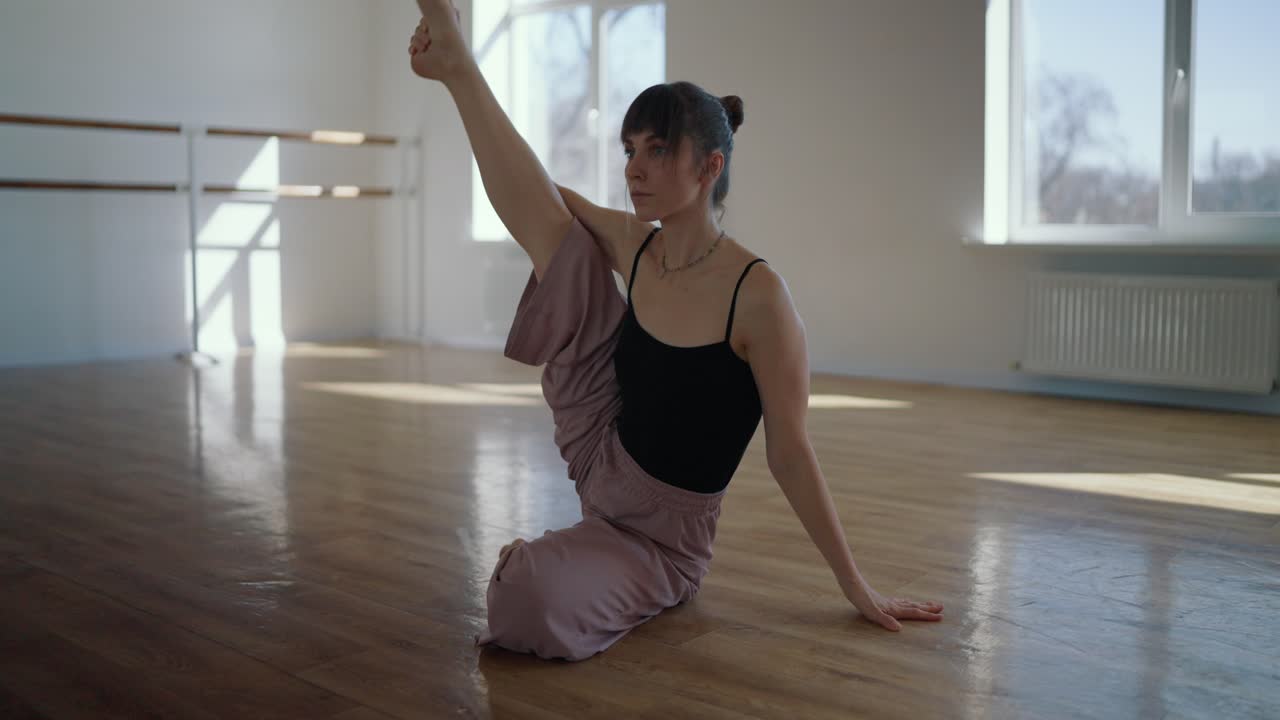 A woman practicing yoga and stretching indoors