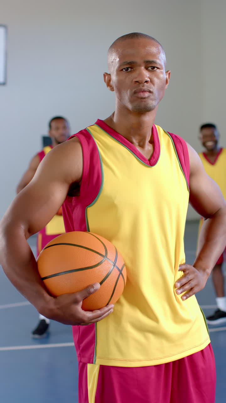 Video verticale: Con in mano un pallone da basket, un cestista è in piedi con sicurezza sul campo con un compagno di squadra