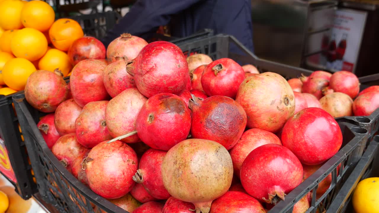 Granatæbler og appelsiner ved en frugtbod