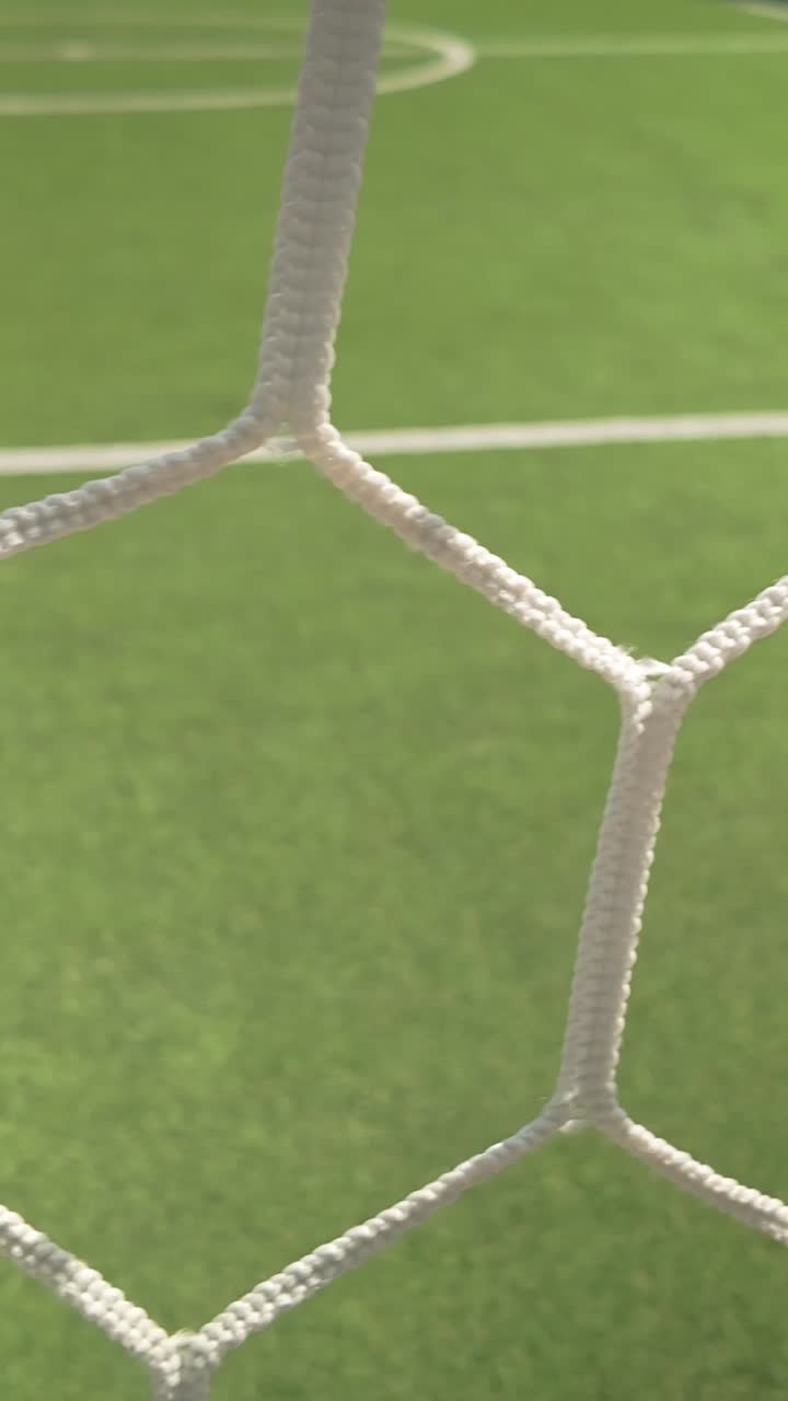 Kamerakørsel bag tomt fodboldmålnet på en 5-mandsbane VERTIKAL.