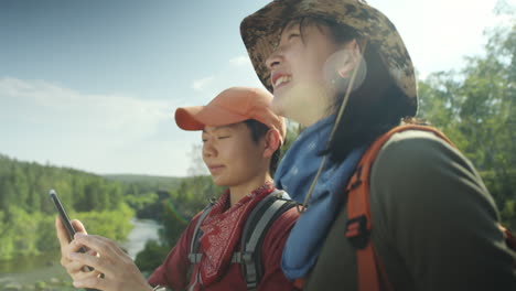female hikers discussing map on phone