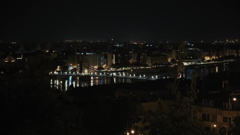 las aguas de la inundación del danubio reflejando las luces de la ciudad mientras el horizonte de budapest brilla por la noche
