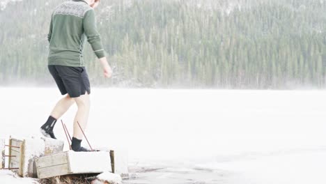 Hombre-Caucásico-Con-Botas-De-Neopreno-Caminando-En-Un-Lago-Congelado-Durante-La-Temporada-De-Invierno