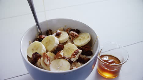 honey pouring into a fruit cereal bowl 4k