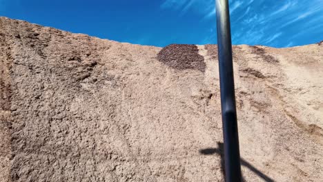 disparo panorámico de una cinta transportadora dejando caer trozos de madera en una pila masiva