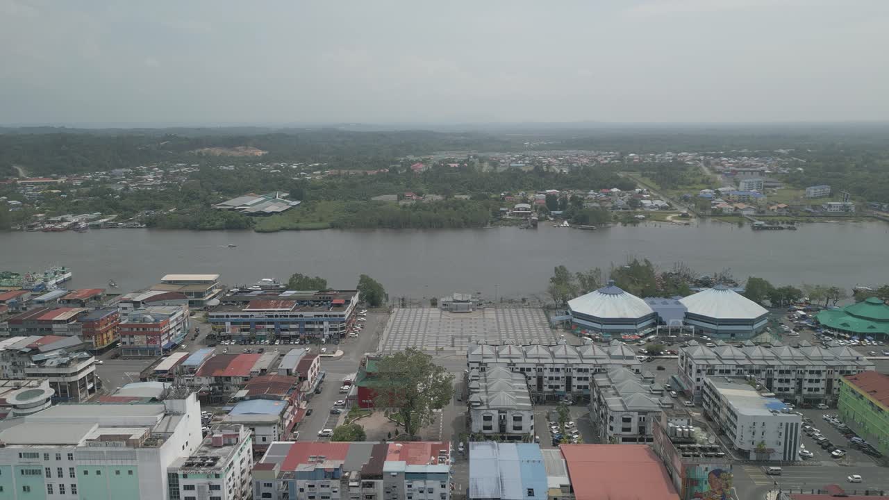 Splendida vista aerea con drone della città di Bintulu, Sarawak, con fiume, barca e piccola nave mercantile, accanto al mercato umido e, sullo sfondo, il nuovo ponte di Bintulu e anche una piccola pista di atterraggio inutilizzata.