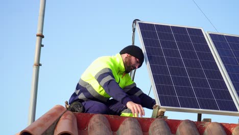 Primer-Plano-De-Un-Técnico-Con-Uniforme-Instalando-Paneles-Solares-Sobre-Un-Techo-De-Ladrillo