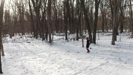 Woman-wearing-active-exercise-clothes-walking-alone-on-winter-snowy-forest-path