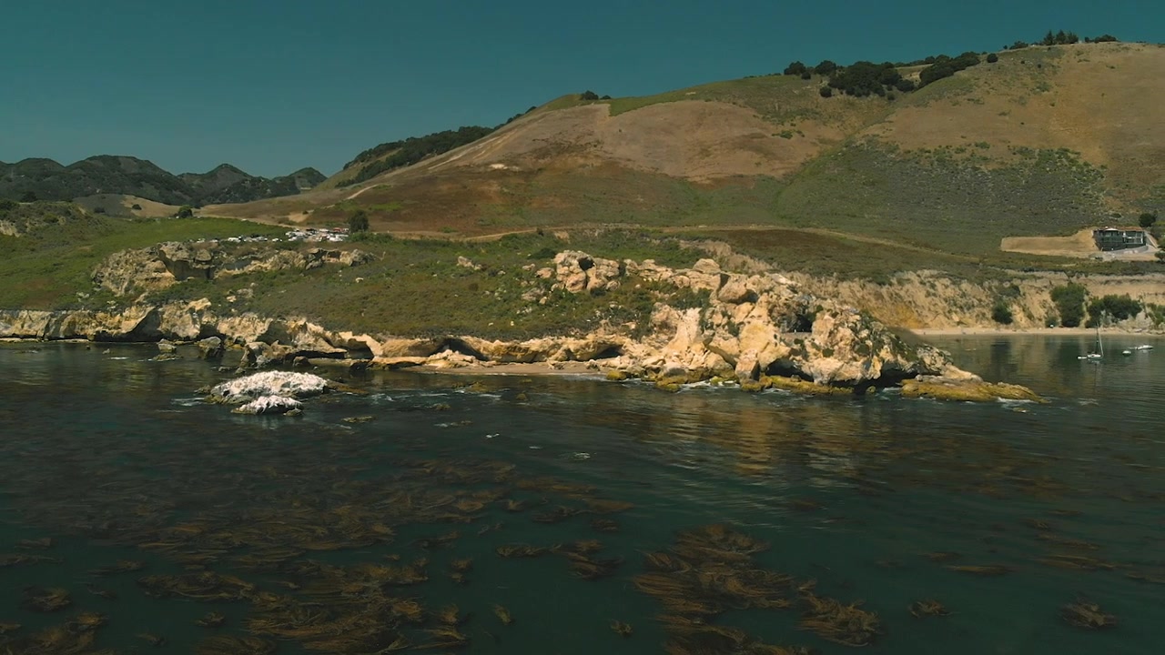 Vista aerea di un paesaggio costiero roccioso con colline verdi e oceano