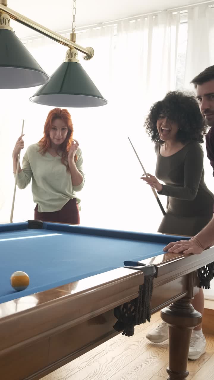 Black woman successfully hitting pool ball