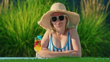 woman relaxing by the pool with a cocktail