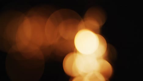 múltiples luces naranjas cálidas parpadeando sobre un fondo negro