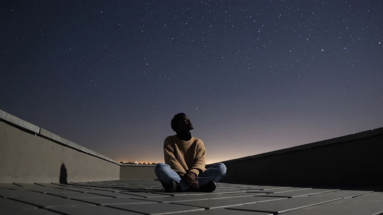 Uomo che contempla il cielo notturno su un tetto