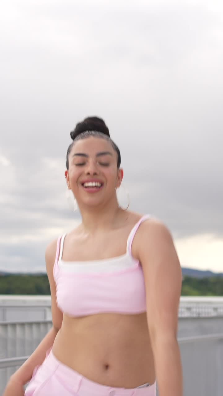 Woman in Pink Outfit Dancing on a Bridge