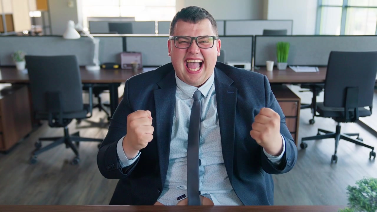 Uomo d'affari entusiasta in intimo che celebra il successo in ufficio